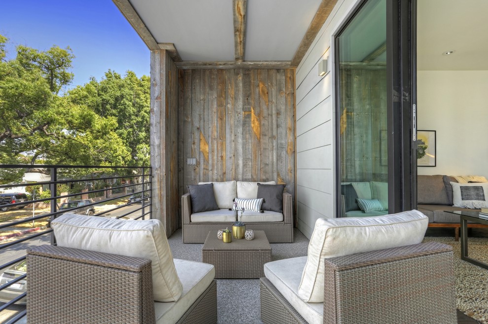 This is an example of a small rustic metal railing balcony in Los Angeles with a roof extension.