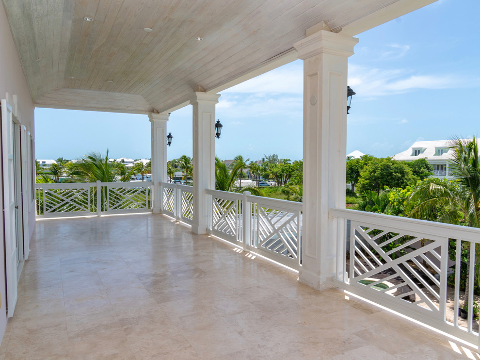 Photo of an expansive nautical metal railing balcony in Other with a roof extension.