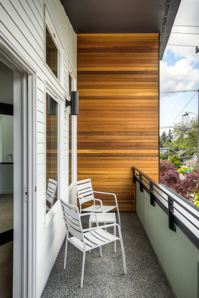 This is an example of a small contemporary balcony in Seattle with a roof extension.