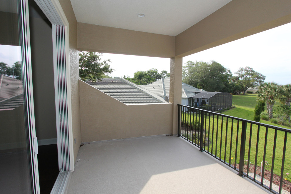 Inspiration for a large traditional metal railing balcony in Orlando with a roof extension.