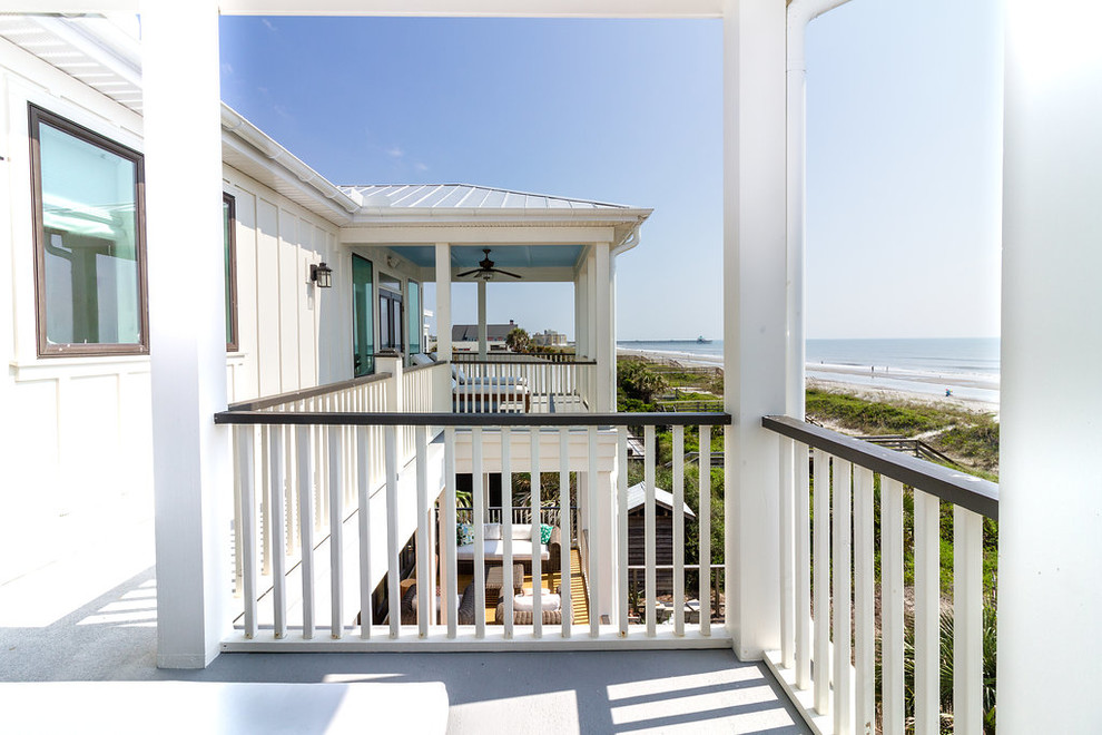 Inspiration for a mid-sized coastal wood railing balcony remodel in Charleston with a roof extension