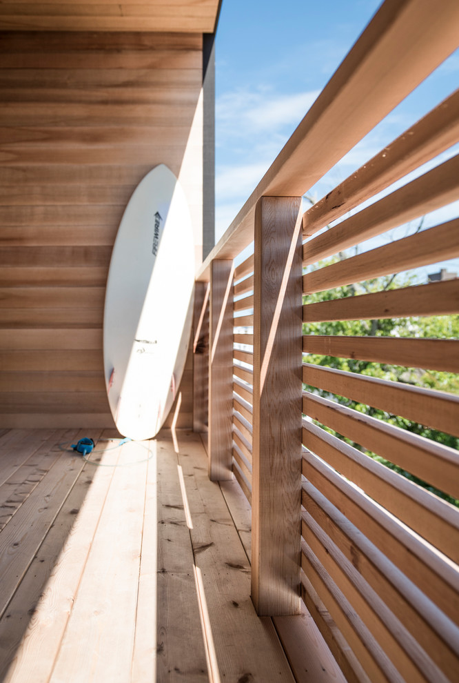 Idéer för en modern balkong, med takförlängning och räcke i trä
