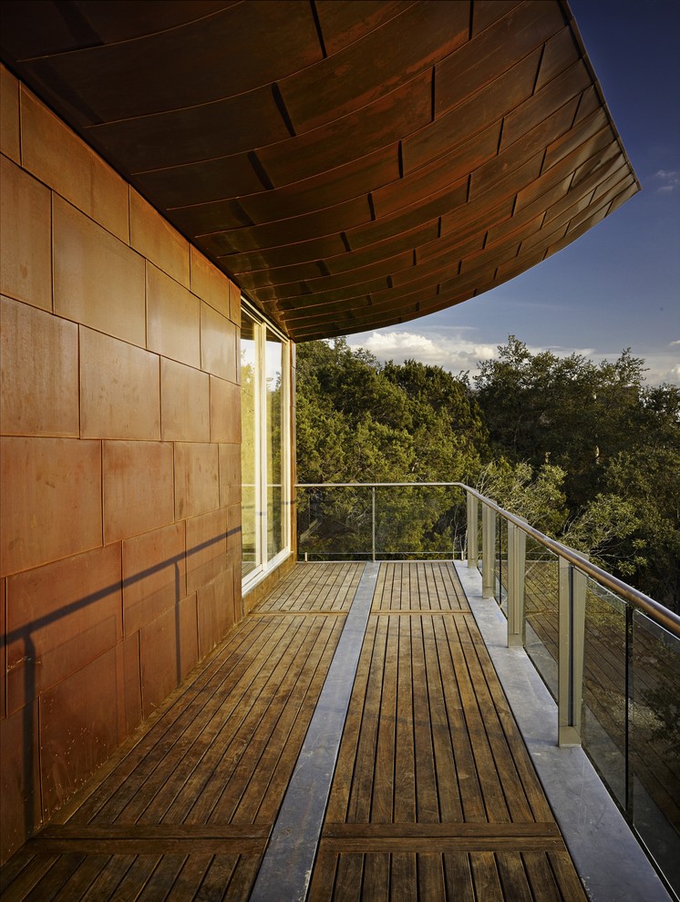 Bild på en stor funkis balkong, med takförlängning och räcke i glas