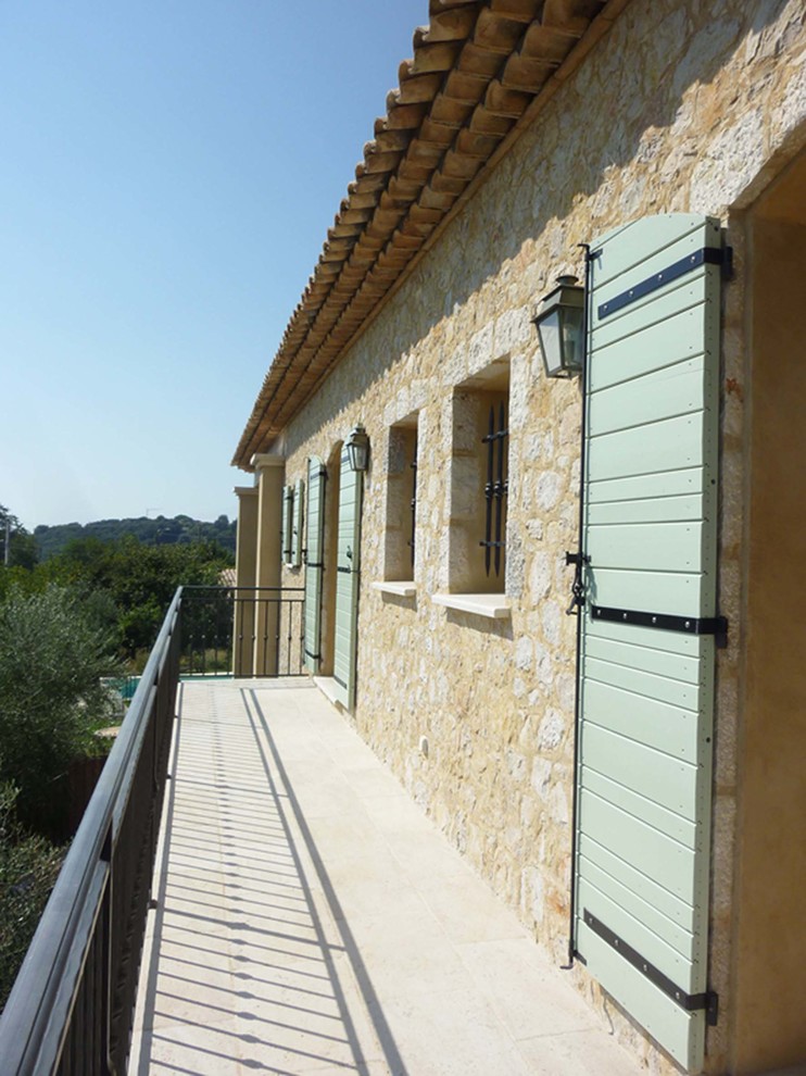 На фото: большой балкон и лоджия в средиземноморском стиле с металлическими перилами без защиты от солнца с