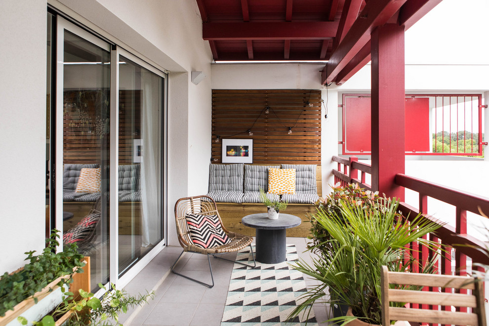 Réalisation d'un grand balcon minimaliste d'appartement avec une extension de toiture et un garde-corps en bois.