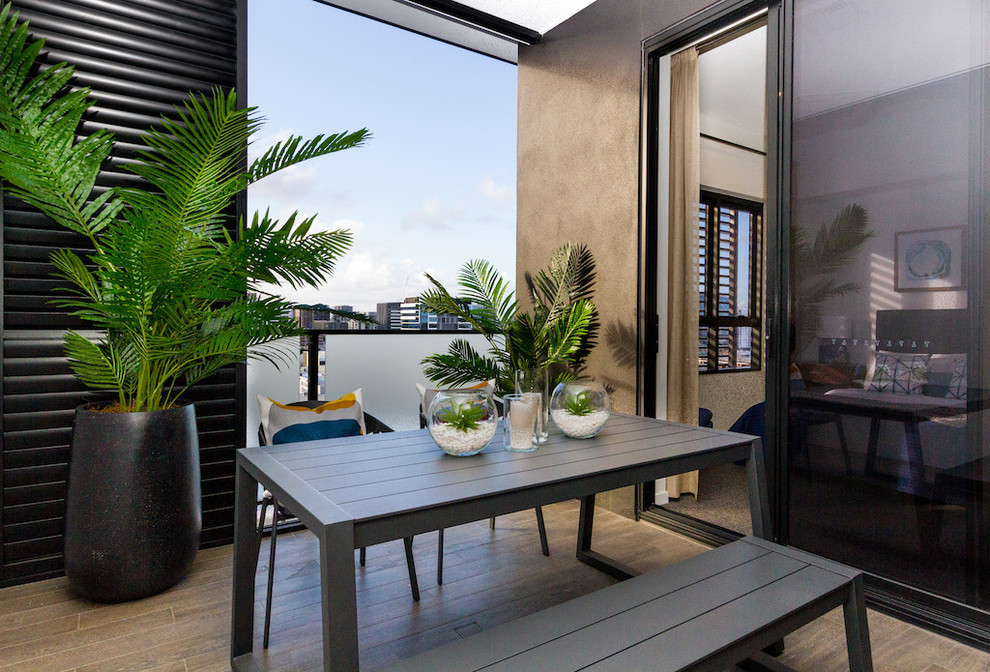 Idée de décoration pour un petit balcon minimaliste avec une extension de toiture et un garde-corps en matériaux mixtes.