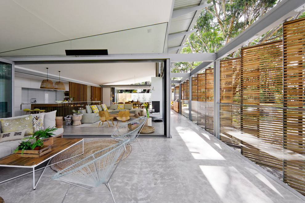 Idées déco pour un grand balcon contemporain avec une extension de toiture et un garde-corps en verre.