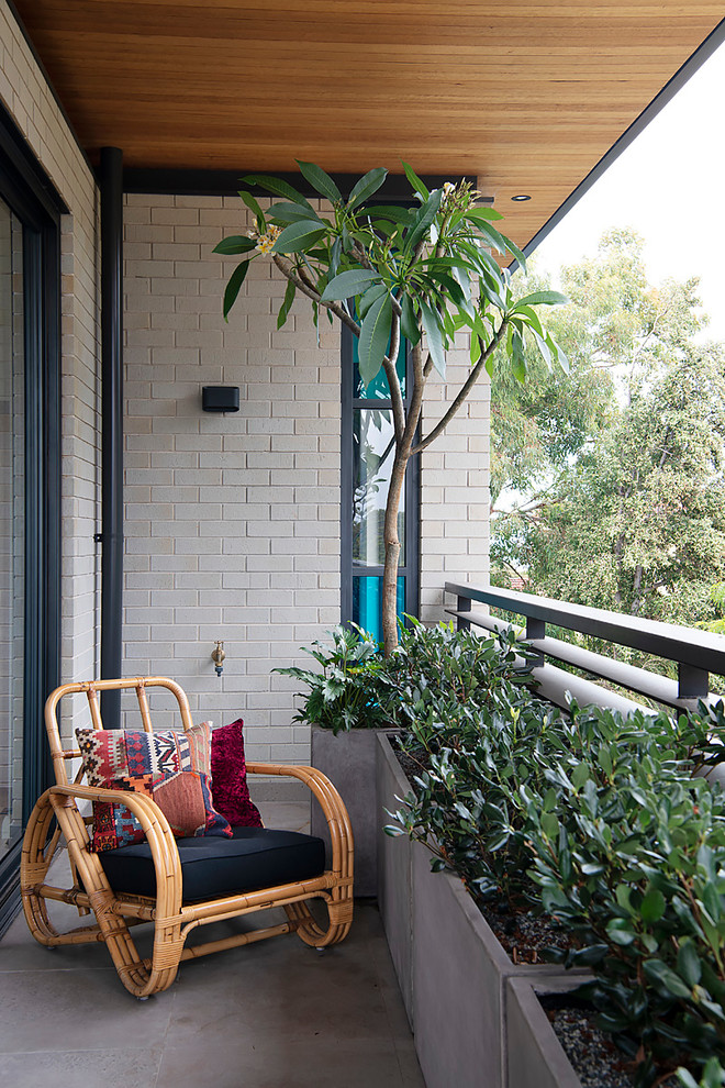Idée de décoration pour un petit balcon vintage avec une extension de toiture et un garde-corps en métal.