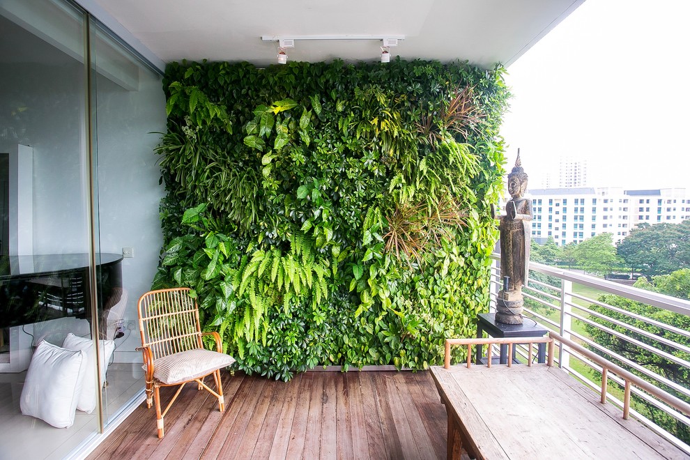 シンガポールにあるアジアンスタイルのおしゃれなベランダ・バルコニー (壁面緑化、張り出し屋根、金属の手すり) の写真