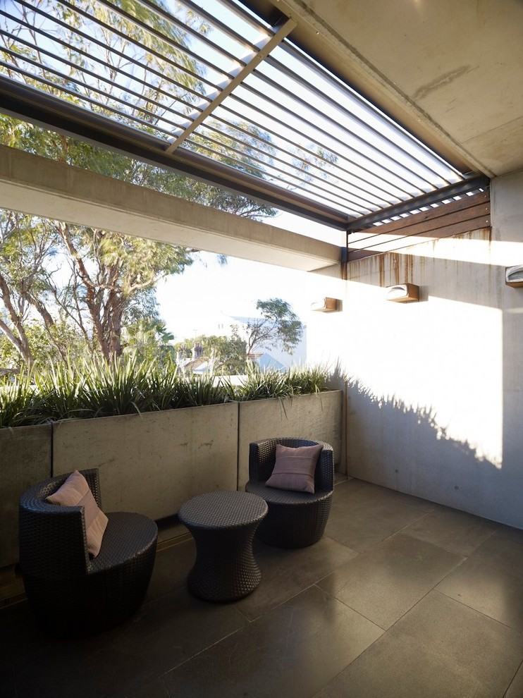 Inspiration pour un petit balcon minimaliste avec des plantes en pot, un auvent et un garde-corps en matériaux mixtes.
