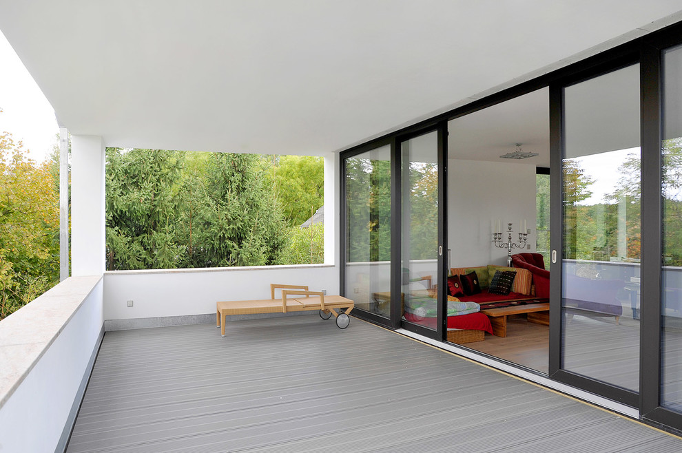 Photo of a large contemporary balcony in Berlin with a roof extension.
