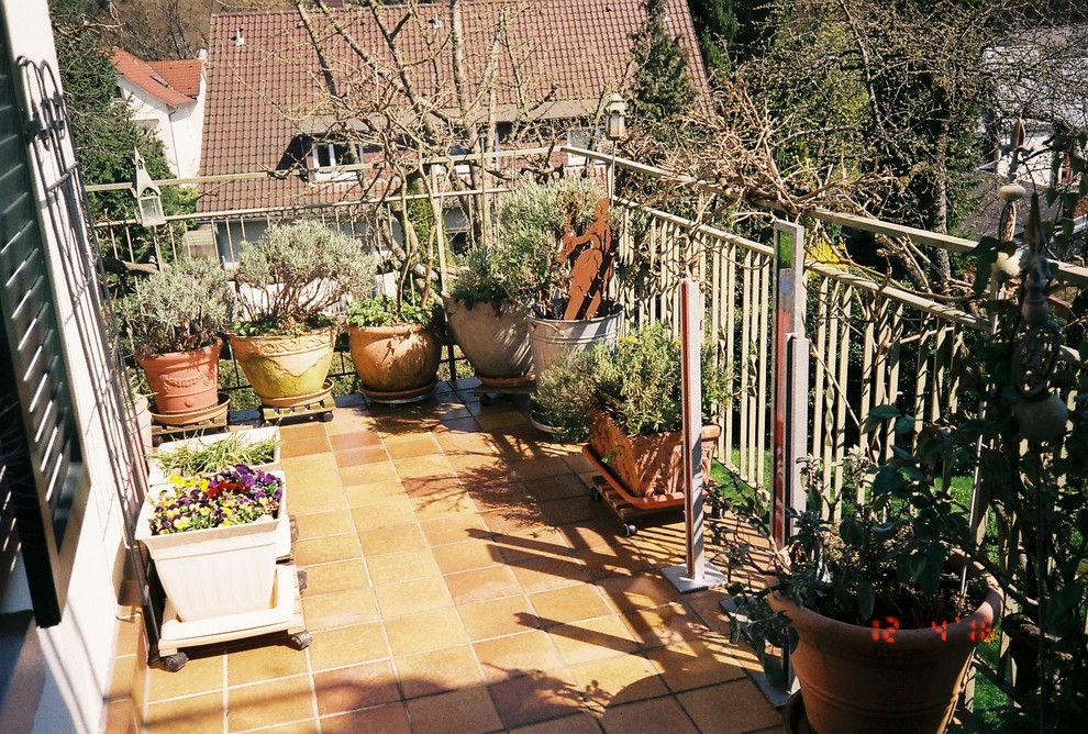 Ispirazione per un ampio balcone mediterraneo con un giardino in vaso e un tetto a sbalzo