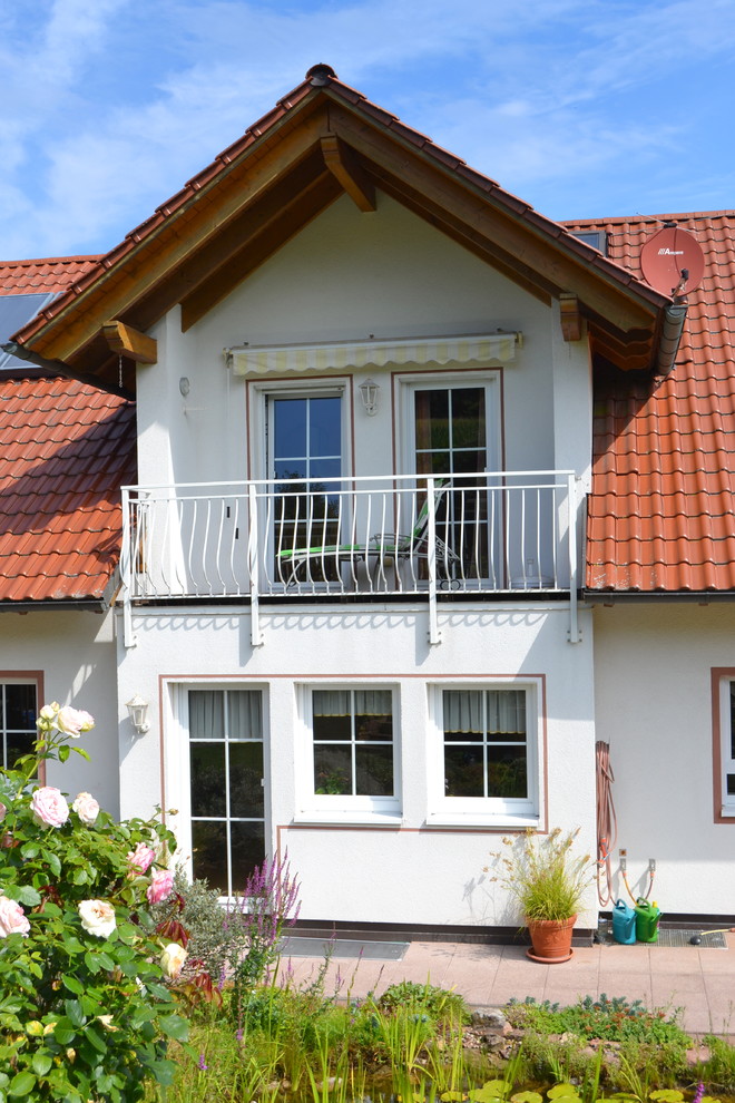 Réalisation d'un petit balcon champêtre avec une extension de toiture et un garde-corps en métal.
