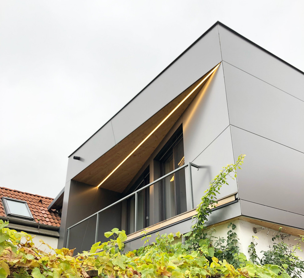 Réalisation d'un petit balcon design avec une extension de toiture et un garde-corps en matériaux mixtes.