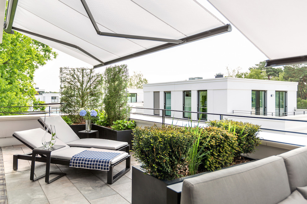 Inspiration pour un grand balcon design avec un auvent, des plantes en pot et un garde-corps en métal.