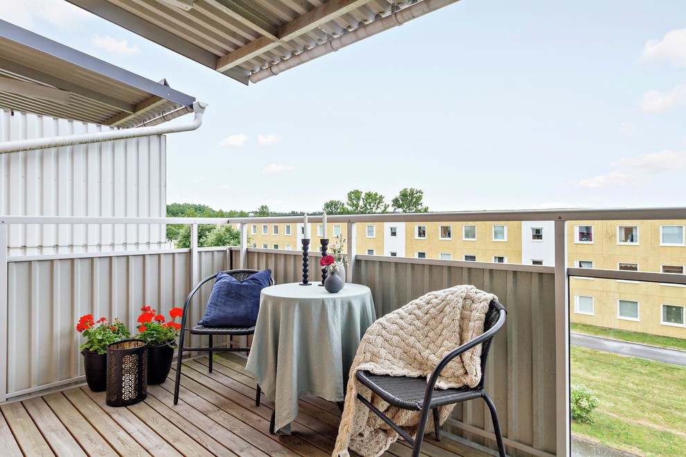 Свежая идея для дизайна: балкон и лоджия в скандинавском стиле с растениями в контейнерах, навесом и металлическими перилами - отличное фото интерьера