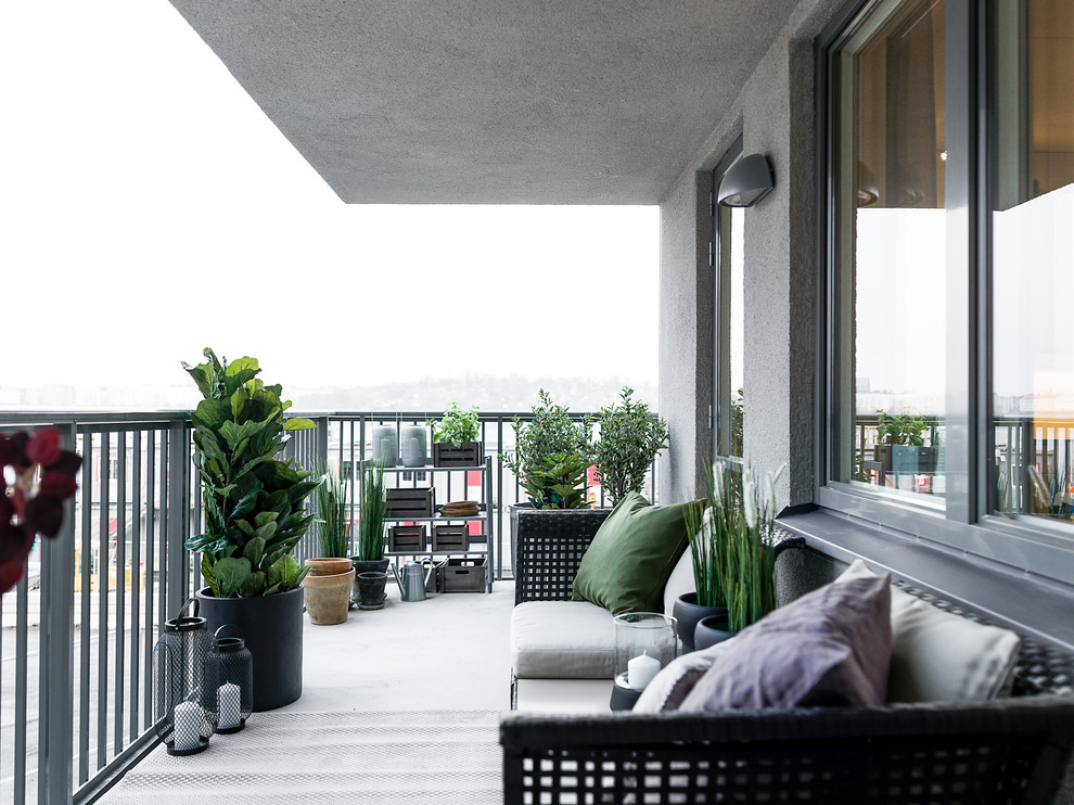 Idéer för en stor minimalistisk balkong, med takförlängning och räcke i metall