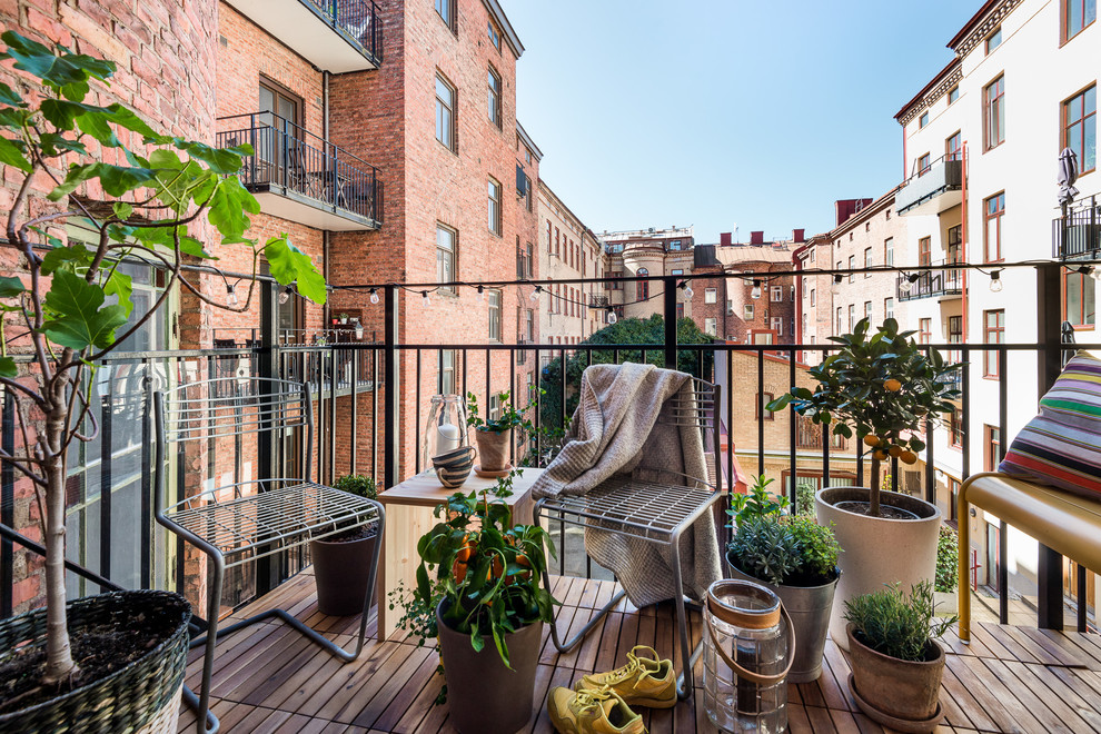 Photo of a medium sized scandi metal railing balcony in Gothenburg with a potted garden and no cover.