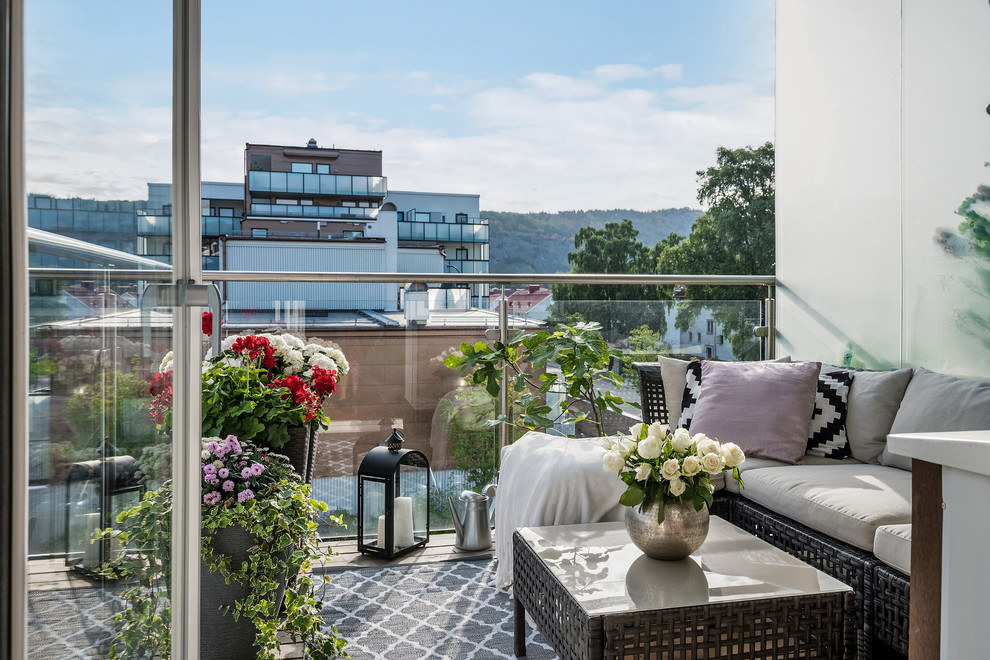 На фото: балкон и лоджия в скандинавском стиле с стеклянными перилами в квартире с