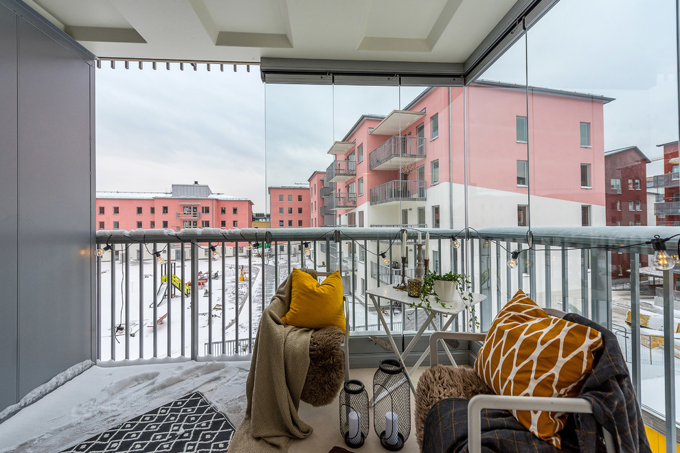 Cette photo montre un balcon scandinave d'appartement avec une extension de toiture et un garde-corps en métal.