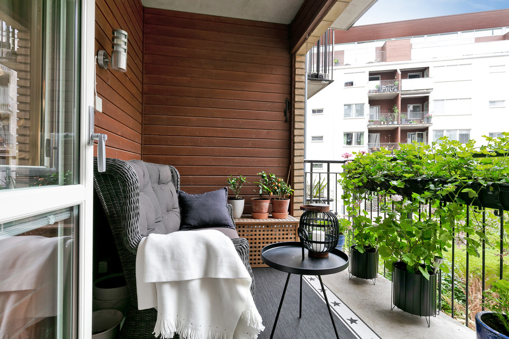 Aménagement d'un balcon scandinave d'appartement avec une extension de toiture et un garde-corps en métal.