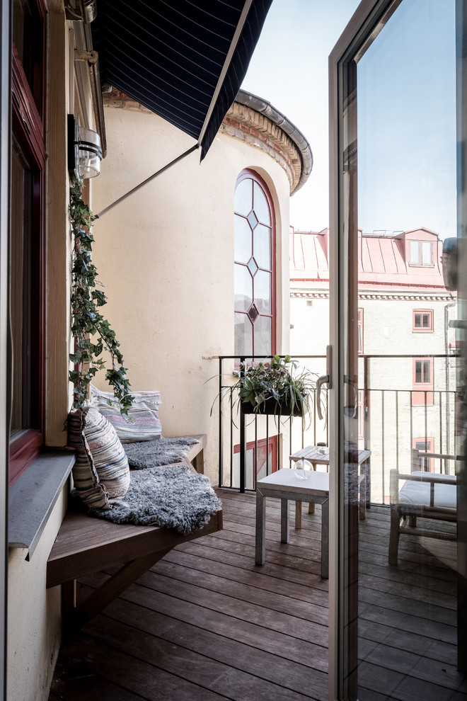 Idee per un piccolo balcone nordico con un giardino in vaso, un parasole e parapetto in metallo