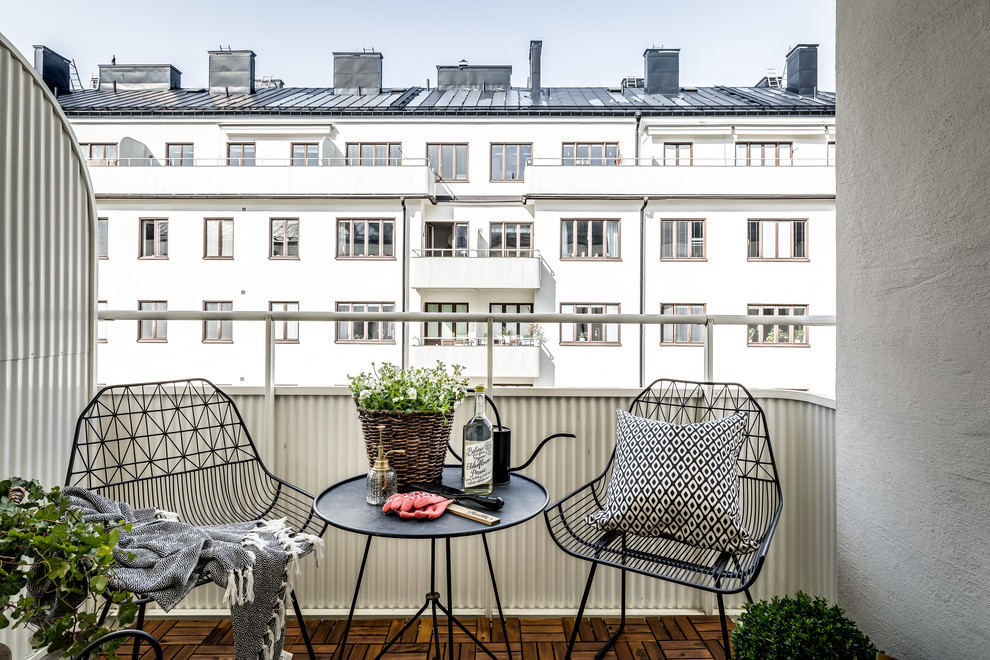 Idee per un balcone scandinavo con un tetto a sbalzo e parapetto in metallo