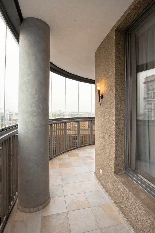 Aménagement d'un balcon contemporain de taille moyenne avec une extension de toiture et un garde-corps en métal.