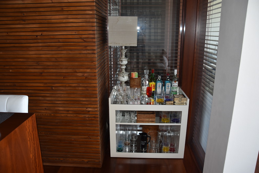 This is an example of a small classic single-wall home bar in Barcelona with open cabinets and white cabinets.