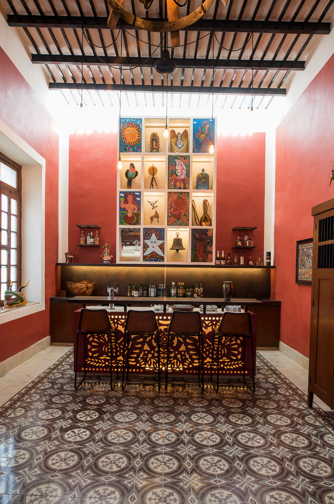 Zweizeilige Mediterrane Hausbar mit Bartheke, dunklen Holzschränken, Küchenrückwand in Braun, grauem Boden und schwarzer Arbeitsplatte in Mexiko Stadt