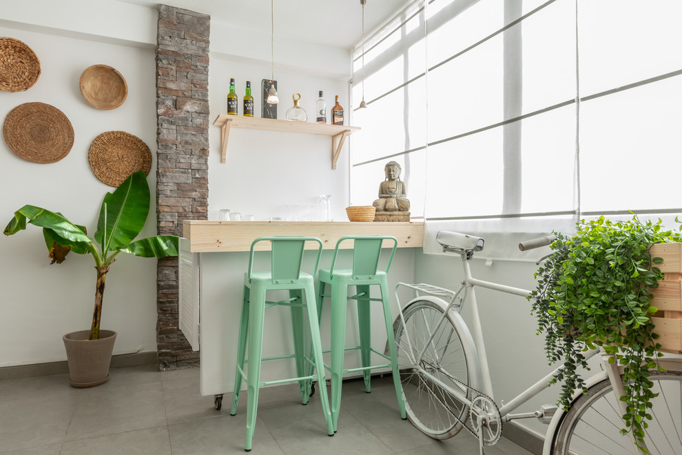 Foto de bar en casa con barra de bar de galera tradicional renovado pequeño con armarios abiertos, encimera de madera, salpicadero blanco, suelo gris y encimeras beige