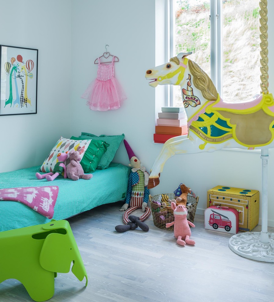 Inspiration för mellanstora moderna barnrum kombinerat med lekrum, med grå väggar och ljust trägolv