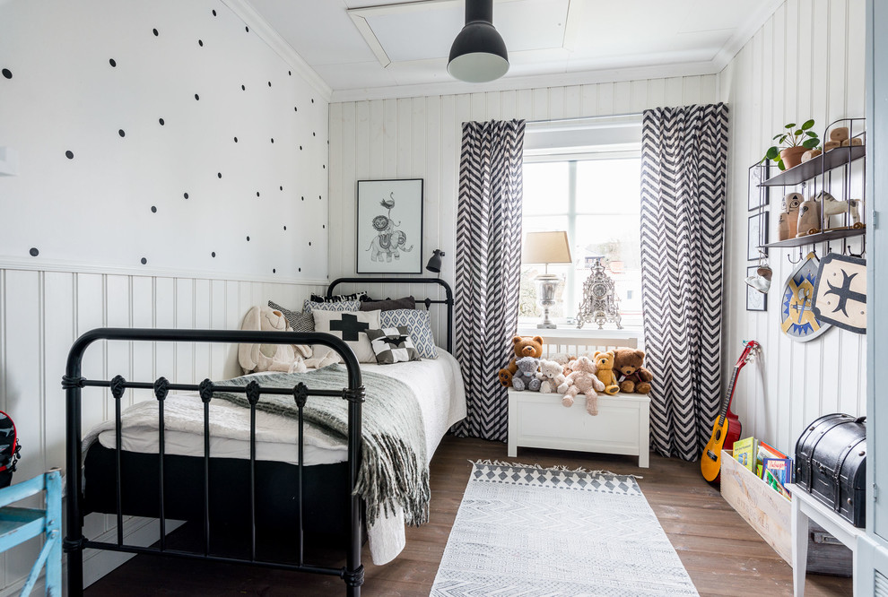 Exempel på ett mellanstort minimalistiskt könsneutralt barnrum kombinerat med sovrum och för 4-10-åringar, med vita väggar och mörkt trägolv