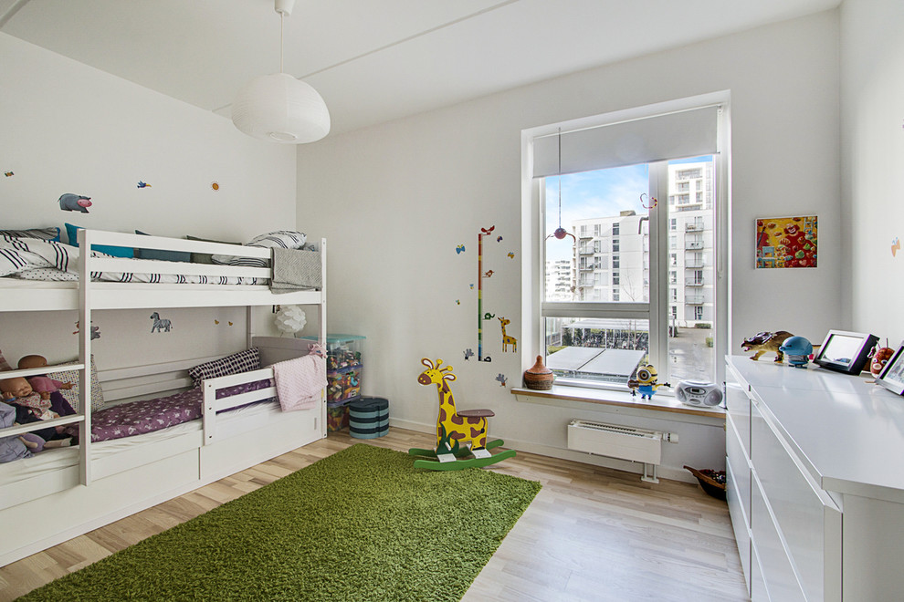 Foto di una cameretta per bambini da 1 a 3 anni nordica di medie dimensioni con pareti bianche e parquet chiaro
