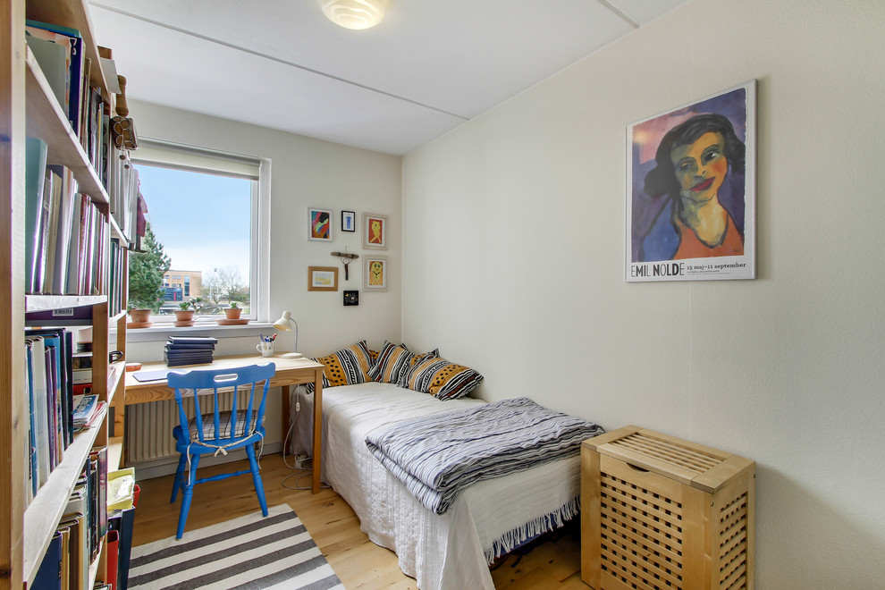 Bild på ett litet eklektiskt barnrum kombinerat med sovrum, med beige väggar och ljust trägolv