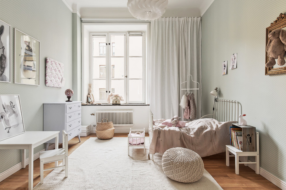 На фото: нейтральная детская среднего размера в скандинавском стиле с спальным местом, паркетным полом среднего тона и зелеными стенами для ребенка от 4 до 10 лет