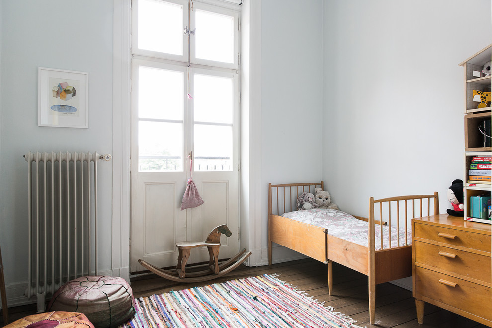 Aménagement d'une chambre neutre de 1 à 3 ans scandinave de taille moyenne avec un mur blanc et parquet foncé.