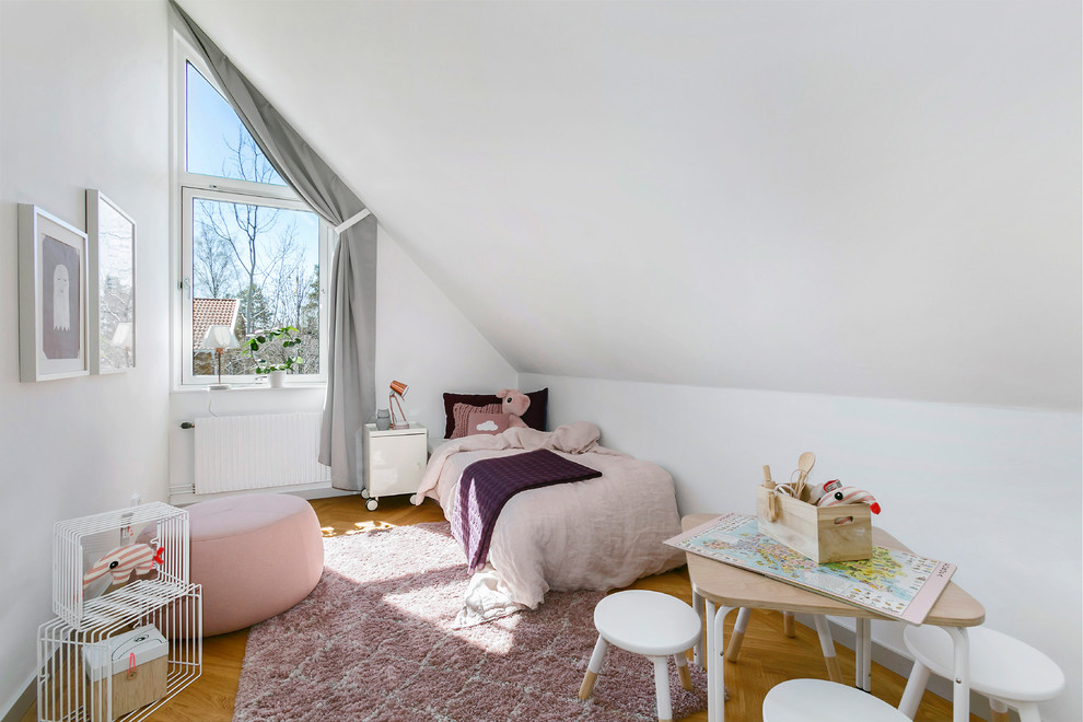 Inspiration för nordiska flickrum kombinerat med sovrum och för 4-10-åringar, med vita väggar och brunt golv