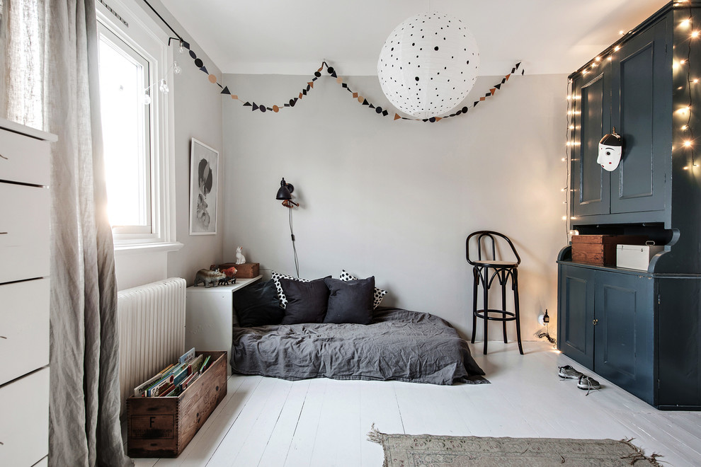 Minimalistisk inredning av ett mellanstort könsneutralt barnrum kombinerat med sovrum, med vita väggar, målat trägolv och vitt golv