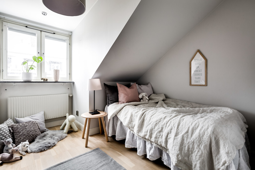 Exempel på ett nordiskt flickrum kombinerat med sovrum och för 4-10-åringar, med grå väggar, ljust trägolv och beiget golv