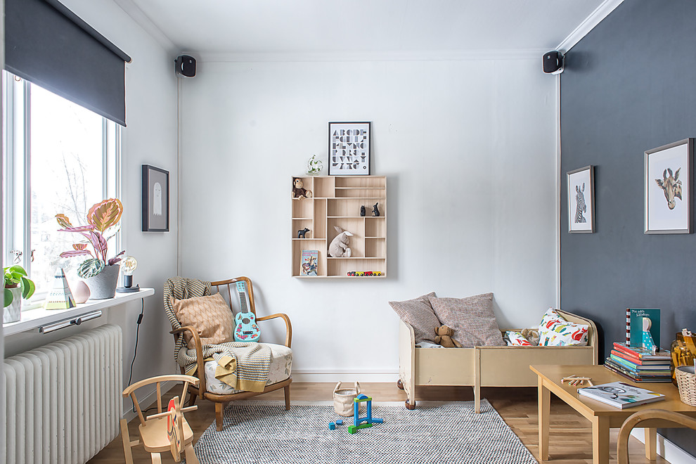 Idéer för att renovera ett mellanstort nordiskt könsneutralt småbarnsrum kombinerat med sovrum, med mellanmörkt trägolv