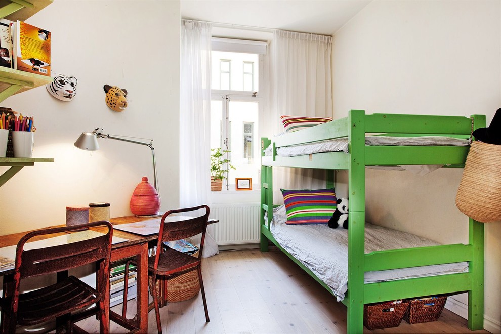 Medium sized rustic gender neutral teen’s room in Stockholm with white walls and light hardwood flooring.