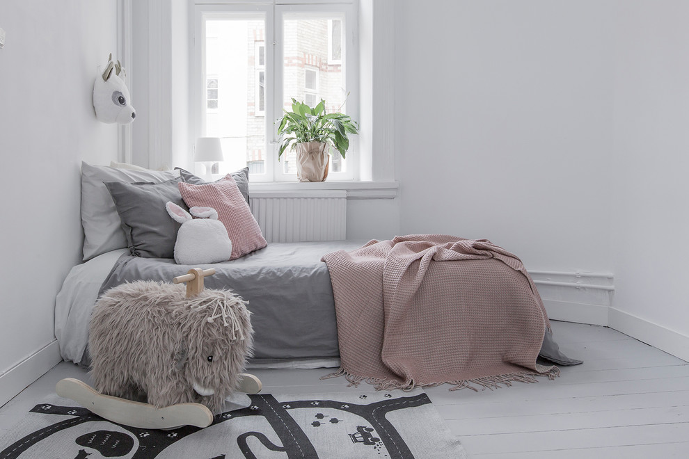 Nordisches Mädchenzimmer mit Schlafplatz, weißer Wandfarbe, gebeiztem Holzboden und grauem Boden in Malmö
