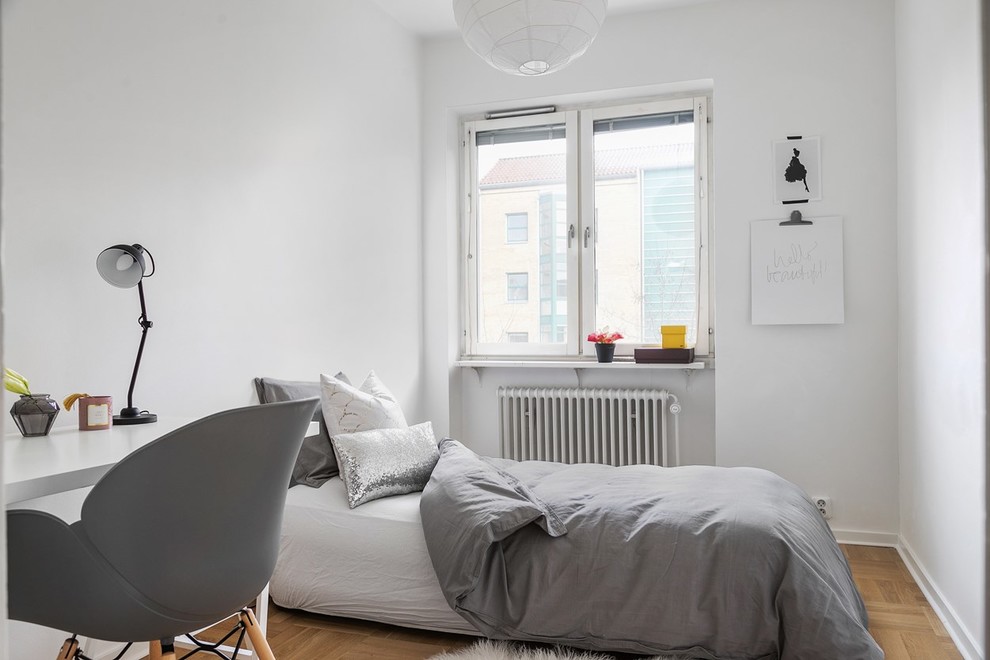 Foto på ett minimalistiskt barnrum kombinerat med sovrum, med vita väggar, mellanmörkt trägolv och brunt golv