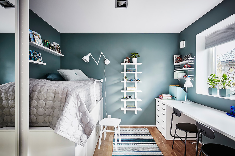 Foto på ett mellanstort nordiskt könsneutralt barnrum för 4-10-åringar och kombinerat med sovrum, med blå väggar, mellanmörkt trägolv och brunt golv
