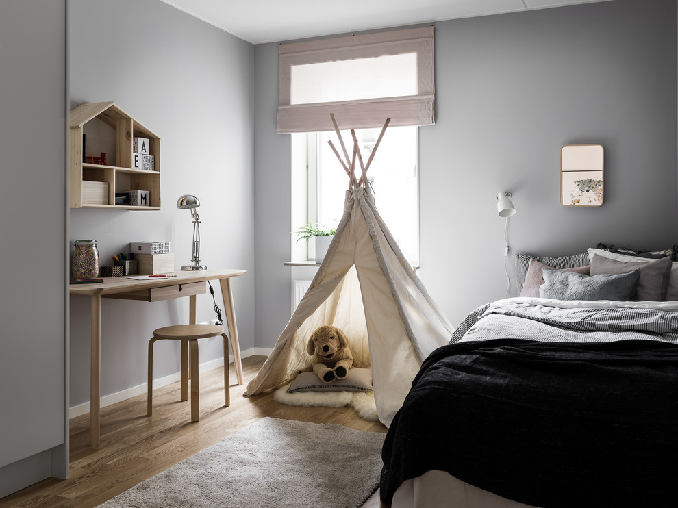 Idéer för mellanstora skandinaviska könsneutrala barnrum kombinerat med sovrum och för 4-10-åringar, med grå väggar, mellanmörkt trägolv och brunt golv