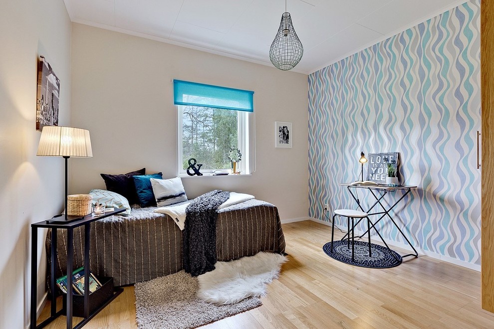 Inspiration för stora moderna könsneutrala tonårsrum kombinerat med sovrum, med flerfärgade väggar och ljust trägolv