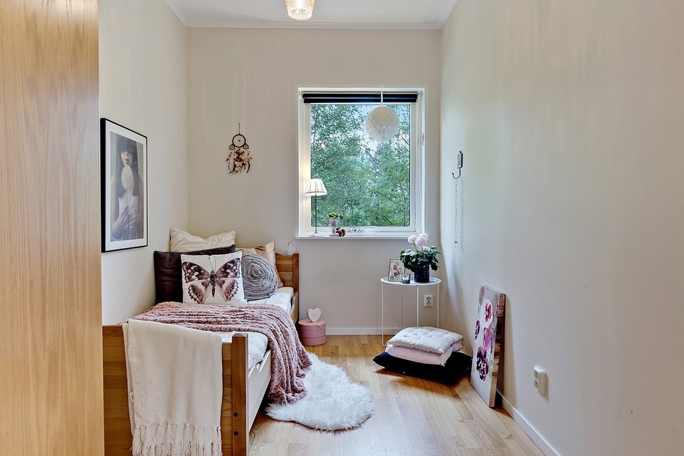 Design ideas for a medium sized scandinavian children’s room for girls in Stockholm with beige walls and light hardwood flooring.