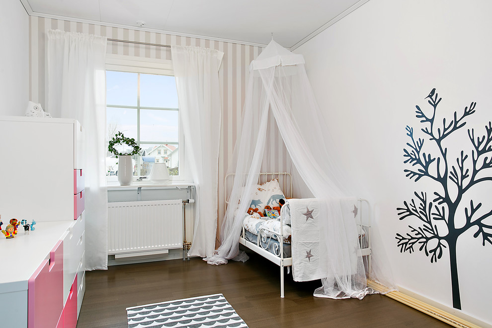 Inspiration för ett mellanstort nordiskt könsneutralt barnrum kombinerat med sovrum och för 4-10-åringar, med vita väggar och mörkt trägolv