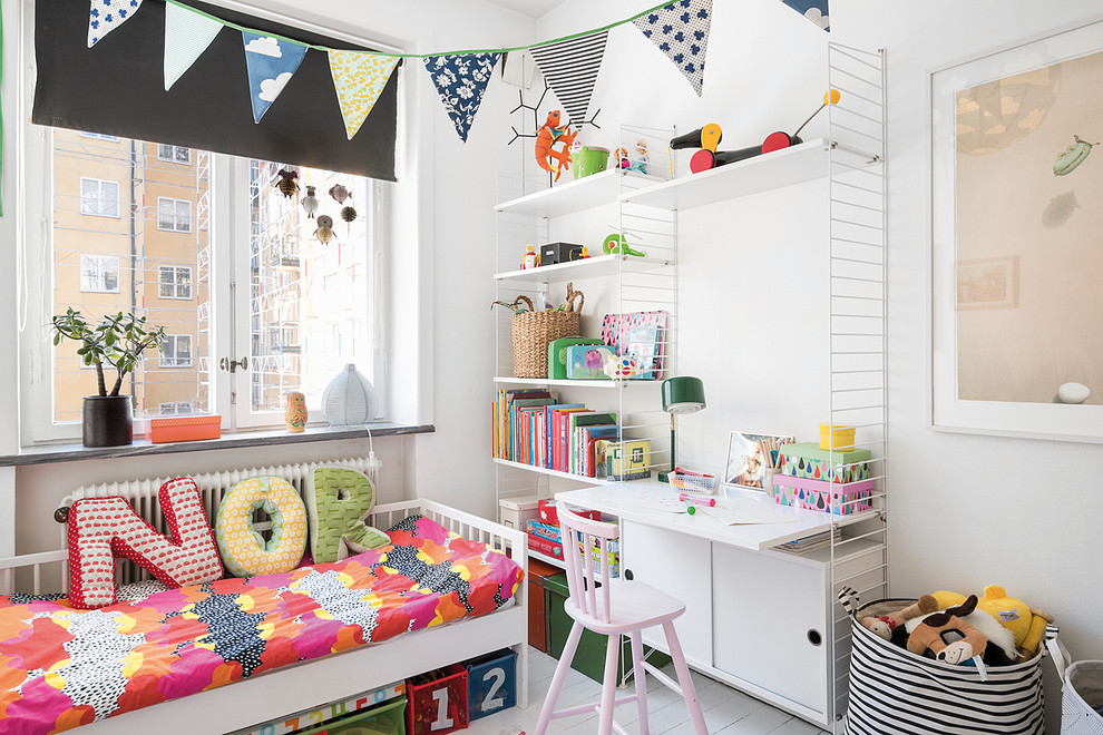 Photo of a small scandinavian gender neutral children’s room in Malmo with white walls and painted wood flooring.